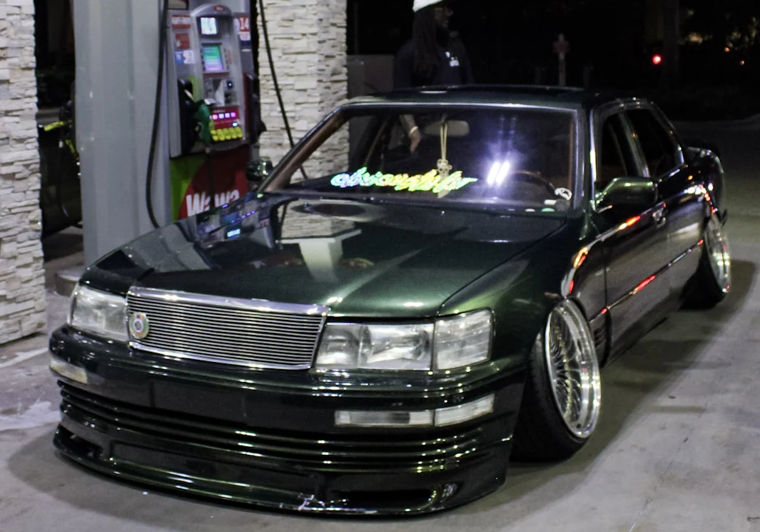 Dark green lowered 1994 Lexus LS400 at night at a gas station
